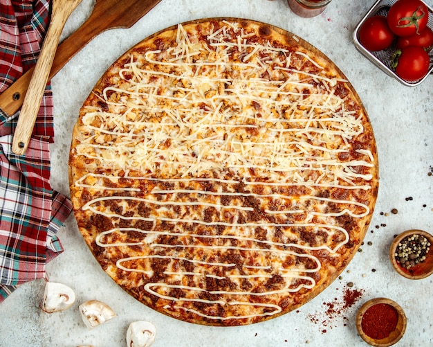 Meat pizza with half covered in extra grated cheese