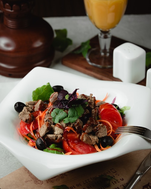 meat salad with tomatoes olives and herbs