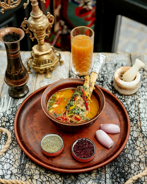 Meat soup with vegetables served with onion barberry and herbs