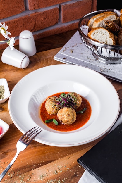 Meatballs with tomato sauce and greens