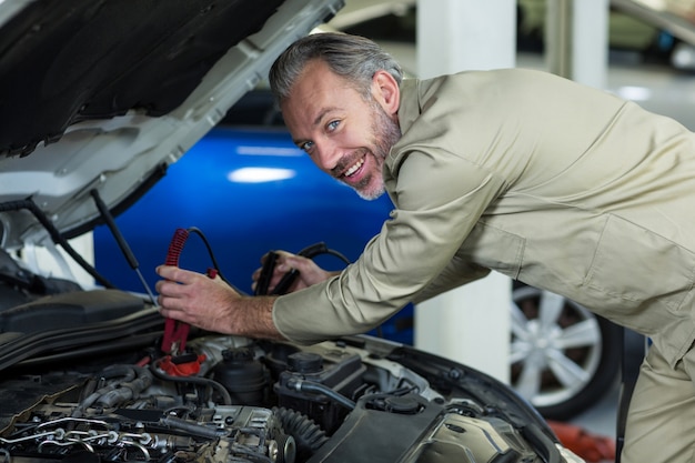 Mechanic attaching jumper cables to car battery