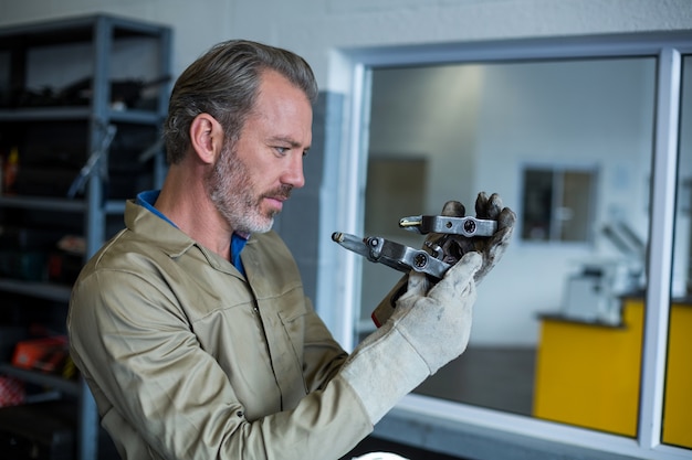 Free Photo mechanic checking a car parts