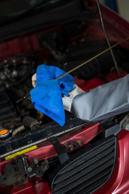 Free photo mechanic checking the oil level in a car engine