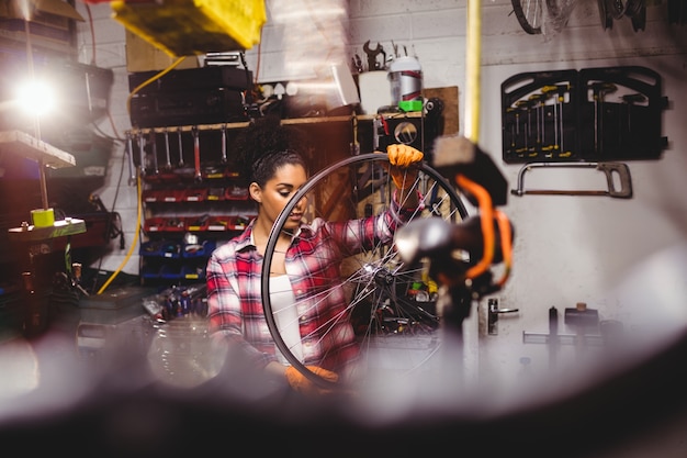 Free Photo mechanic examining a bicycle wheel