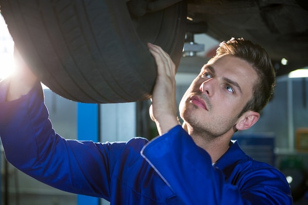 Mechanic examining car tyre