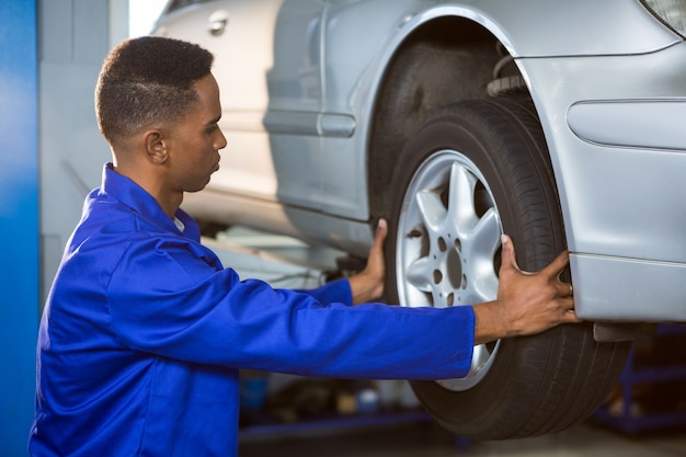 Free photo mechanic fixing a car tyre