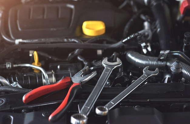 Free photo mechanic hand checking and fixing a broken car in car service garage.