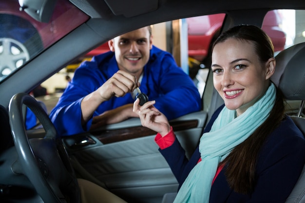 Mechanic handing over key to customer