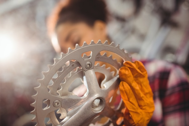 Free photo mechanic holding a bicycle gear