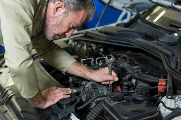 Free Photo mechanic servicing a car engine