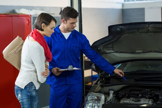 Mechanic showing customer the problem with car