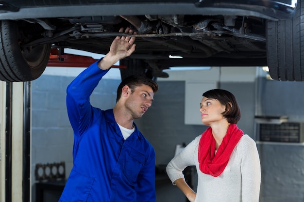 Mechanic showing customer the problem with car