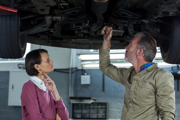 Mechanic showing customer the problem with car