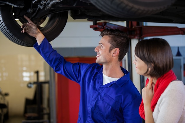 Free Photo mechanic showing customer the problem with car