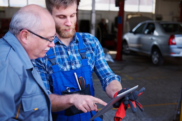 Free photo mechanics checking a planning in a workshop