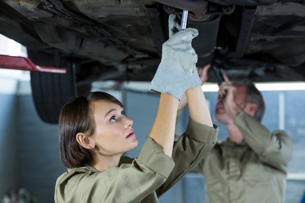 Mechanics examining a car