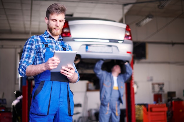 Free photo mechanics repairing a car in the workshop