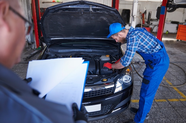 Free Photo mechanics repairing a car in the workshop