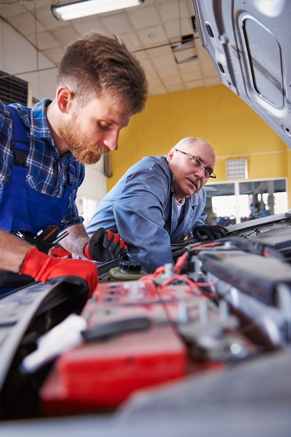 Mechanics repairing a car in the workshop