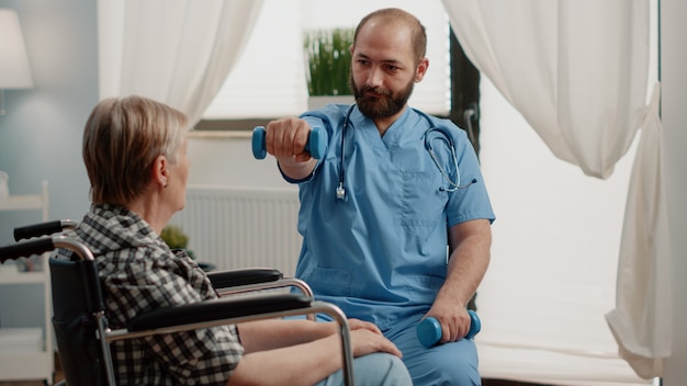 Medical assistant giving assistance to disabled old woman