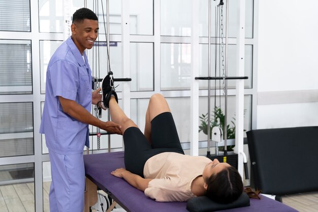 Medical assistant helping patient with physiotherapy exercises