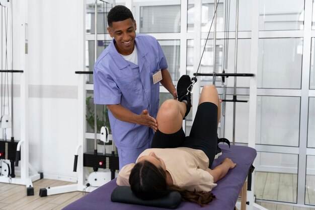 Medical assistant helping patient with physiotherapy exercises