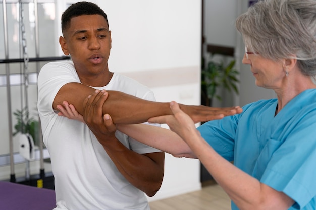 Medical assistant helping patient with physiotherapy exercises