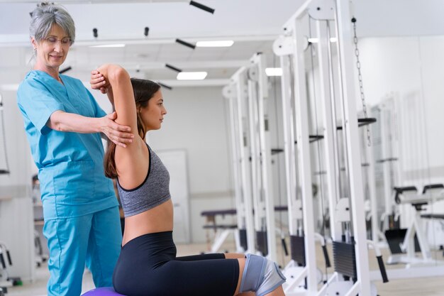 Medical assistant helping patient with physiotherapy exercises