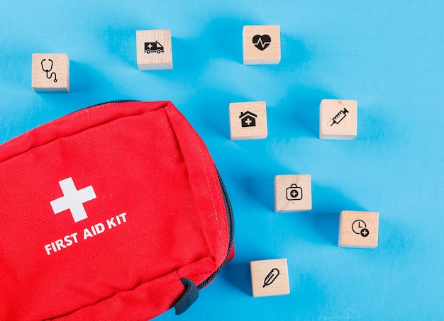 Free Photo medical concept with wooden blocks with icons, first aid bag on blue table flat lay.