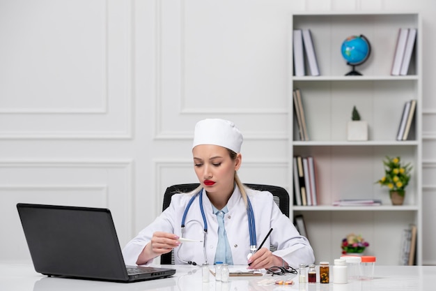 Medical cute lovely doctor in white lab coat and hat with computer holding medicine