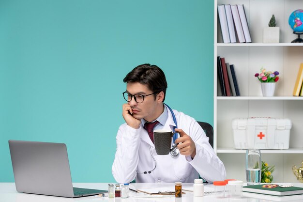 Medical cute smart doctor in lab coat working remotely on computer working focused