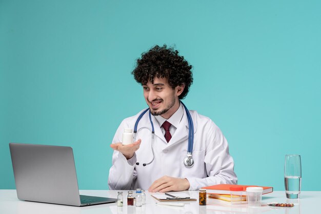 Medical in lab coat young serious handsome doctor working on computer holding white pills