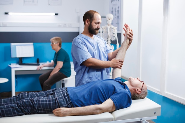 Free photo medical nurse helps old man with massage