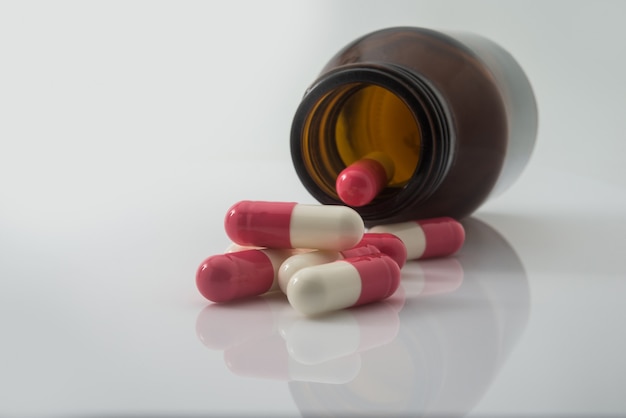 Medical pills spilling out of a toppled from pill bottle