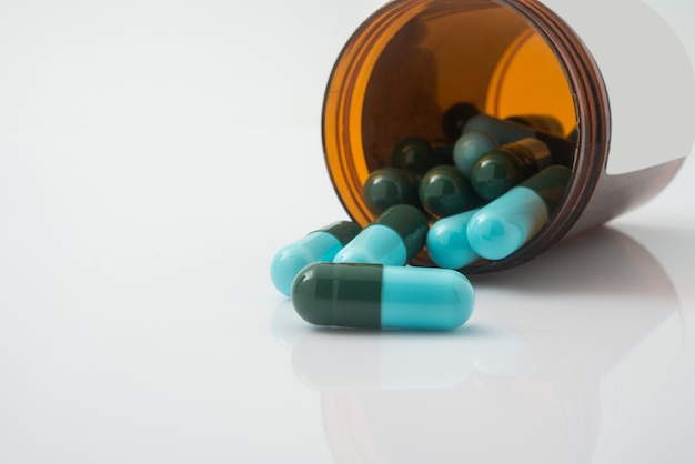 Medical pills spilling out of a toppled from pill bottle