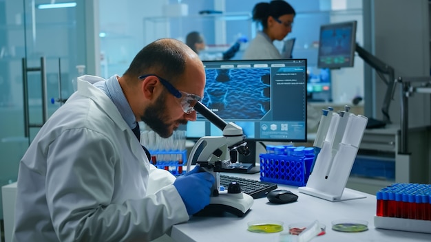 Free photo medical research scientist conducting vaccine development under digital microscope in a biological applied science laboratory