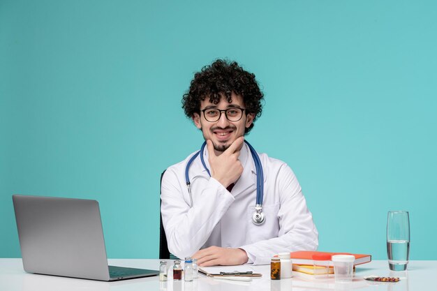 Medical serious cute handsome doctor working on computer in lab coat wearing glasses