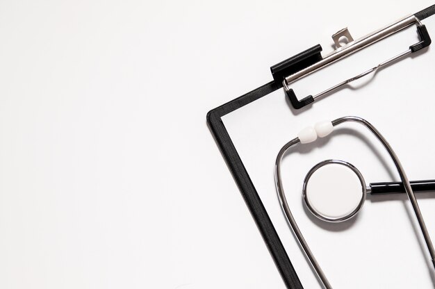 Medical stethoscope or phonendoscope isolated on white background cut out. Stethoscope and clipboard with blank white sheet of paper and copy space. Medical concept