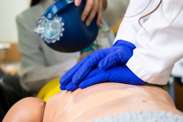 Free photo medical students practicing emergency cardiopulmonary resuscitation on a medical practice doll