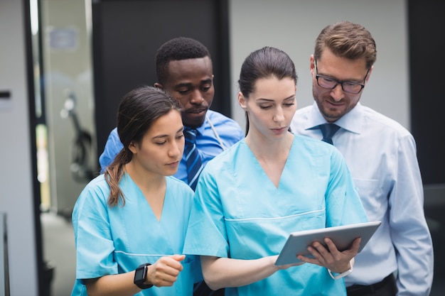 Medical team discussing over digital tablet