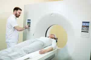 Free photo medical technician starting mri scan procedure of mature patient at clinic