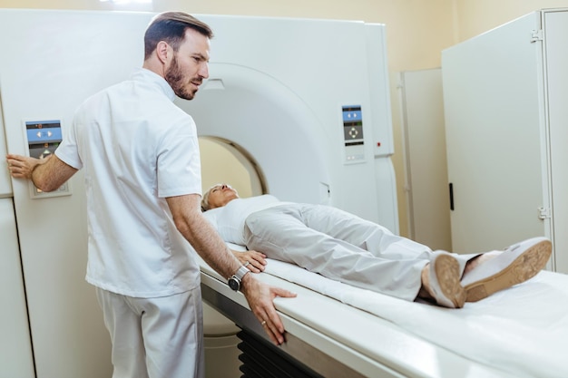 Free Photo medical technician starting mri scanning examination of a female patient at medical clinic