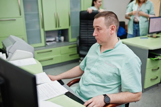 Free photo medical theme doctor in the mri office at diagnostic center in hospital sitting near monitors of computer