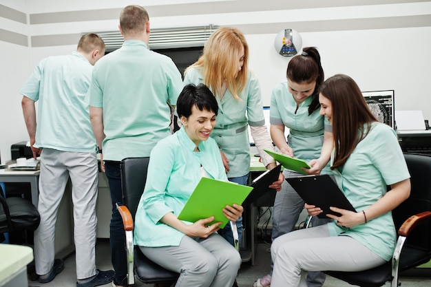 Free photo medical themeobservation room with a computer tomograph the group of female doctors with clipboards meeting in the mri office at diagnostic center in hospital