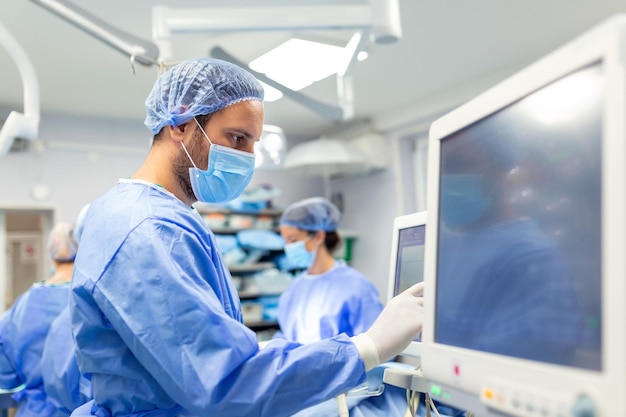 Medical ventilator being monitored by anaesthetist surgeon using monitor in operating room