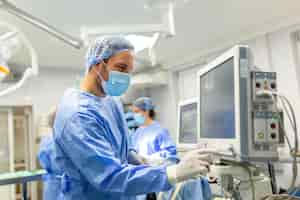 Free photo medical ventilator being monitored by anaesthetist surgeon using monitor in operating room