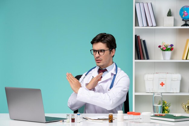 Free Photo medical working on computer remotely serious cute smart doctor in lab coat stopping the call