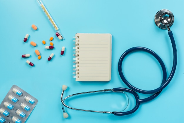 Free photo of medicine, medical supplies placed with doctor tools on a blue  .