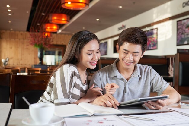 Mediu shot of Asian couple having date in coffeeshop