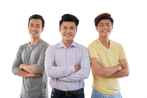 Medium closeup of three Asian friends standing arms folded